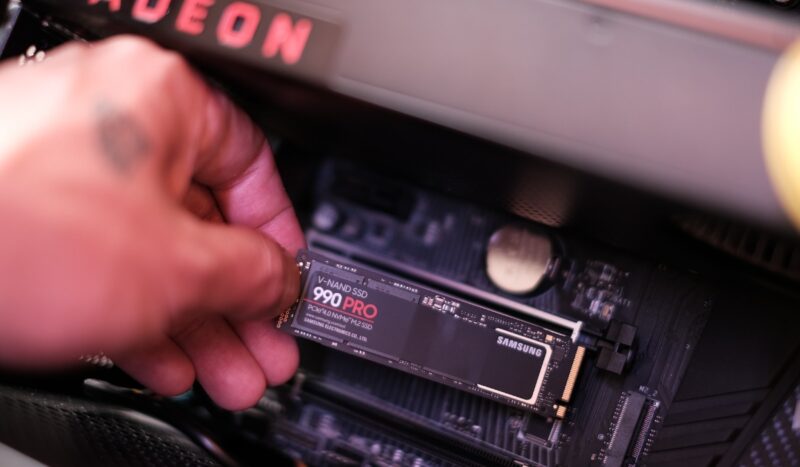 Close up of a hand installing a Samsung SSD in a PC