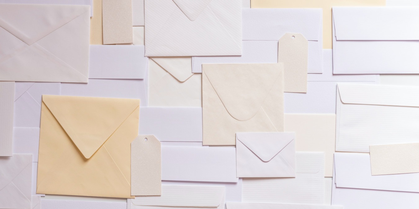 A photograph of a bundle of mail envelopes spread on a surface.
