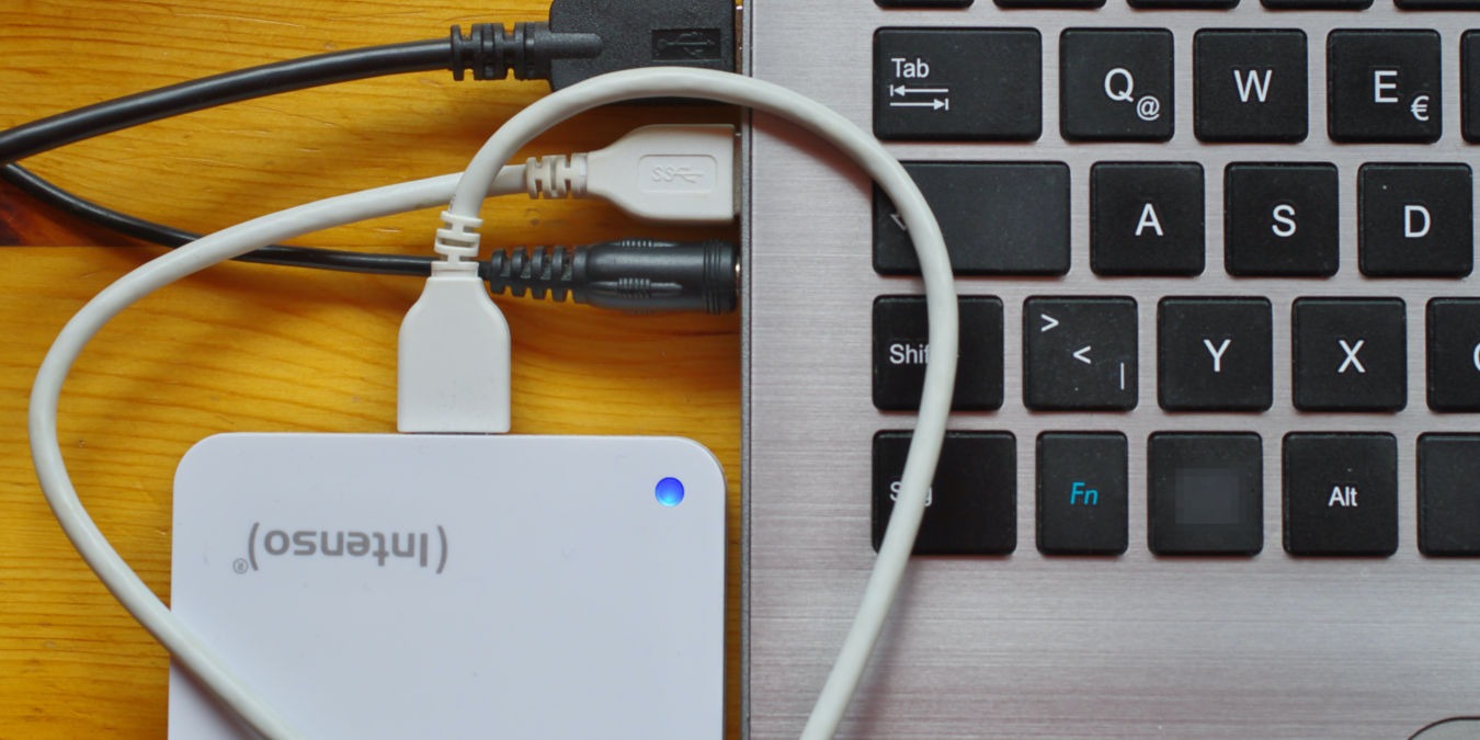 A photograph of a laptop with an external drive attached to it.