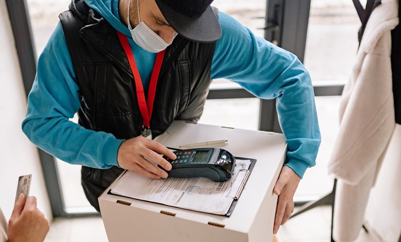 Courier preparing POS in anticipation of payment. 